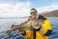 Happy fisherman with cod fish in hands Royalty Free Stock Photo