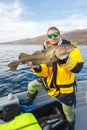 Happy fisherman with cod fish in hands Royalty Free Stock Photo