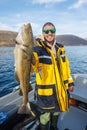 Happy fisherman with cod fish in hands Royalty Free Stock Photo