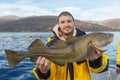 Happy fisherman with cod fish in hands Royalty Free Stock Photo