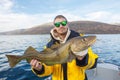 Happy fisherman with cod fish in hands Royalty Free Stock Photo