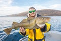 Happy fisherman with cod fish in hands Royalty Free Stock Photo