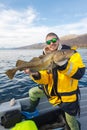 Happy fisherman with cod fish in hands Royalty Free Stock Photo