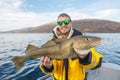 Happy fisherman with cod fish in hands Royalty Free Stock Photo