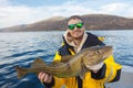 Happy fisherman with cod fish in hands Royalty Free Stock Photo