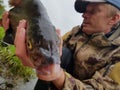 Happy fisherman holding a beautiful common bream