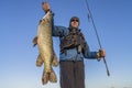 Happy fisherman holding big pike fish trophy and fishing rod Royalty Free Stock Photo