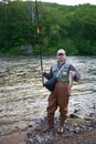 Happy fisherman holds captive salmon.