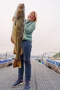 Happy Fisherwoman holding big arctic cod. Norway happy fishing. Woman with cod fish in hands Royalty Free Stock Photo
