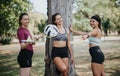 Smiley, sports females standing under tree in the park after training. They are holding badminton rackets, a ball and Royalty Free Stock Photo