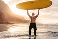 Happy fit senior having fun surfing at sunset time - Sporty bearded man training with surfboard on the beach