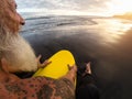 Happy fit senior man sitting on surfboard watching sunset time - Back view bearded surfer having fun on surfing day Royalty Free Stock Photo