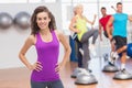 Happy fit woman standing hands on hips at gym Royalty Free Stock Photo