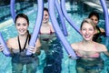 Happy fitness class doing aqua aerobics with foam rollers Royalty Free Stock Photo