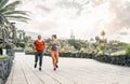 Happy fitness couple running outdoor - Fit joggers friends training outside