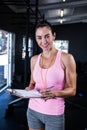 Happy fitness instructor holding clipboard in gym Royalty Free Stock Photo