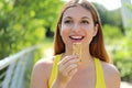 Happy fitness woman holding an energy bar. Close up of sporty girl eating a cereal snack outdoor Royalty Free Stock Photo