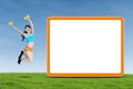 Happy fitness woman jumps next to blank board Royalty Free Stock Photo