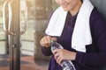 Happy fitness woman looking bottled water in her hand,refreshing after work out