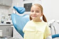 Happy five year old child sitting in the dentist`s office and smiling. Beautiful girl in the chair.
