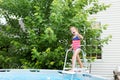 Happy five year old girl entering swimming pool