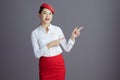 happy flight attendant asian woman pointing isolated on gray Royalty Free Stock Photo