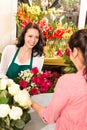 Happy florist making roses bouquet women customer