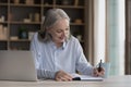 Happy focused mature freelancer woman working at laptop from home Royalty Free Stock Photo