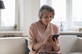 Happy focused mature lady using online app on mobile phone Royalty Free Stock Photo