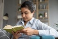 Happy focused pretty young indian woman reading book.