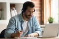 Happy focused young man watching educational lecture on computer. Royalty Free Stock Photo