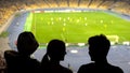 Happy football fans watching game and supporting team at stadium podium, league