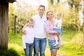 Happy four member family spending spring afternoon together outdoors in orchard Royalty Free Stock Photo