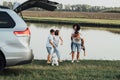 Happy Four Members Family Having Fun Time Outdoors by the River, Mother and Father with Two Teenage Children and Pet Dog Royalty Free Stock Photo