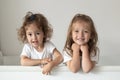 Happy fraternal twins sisters having fun, standing in crib. Happy gitls Royalty Free Stock Photo