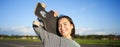 Happy and free asian girl holding cruiser board on shoulders and walking towards camera on empty road, skating on