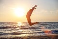 Happy free woman jumping with happiness on the beach in the sunset sun Royalty Free Stock Photo