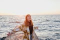 Young woman standing with her arms outstretched at sunrise near the sea Royalty Free Stock Photo