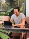Happy freelance man working online on his tablet computer in the cafe Royalty Free Stock Photo