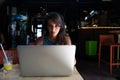 Happy freelance woman using laptop at cafe for work. Young beautiful girl sitting in a coffee shop and working on computer online Royalty Free Stock Photo