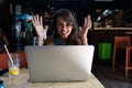 Happy freelance woman using laptop at cafe for work. Young beautiful girl sitting in a coffee shop and working on computer online Royalty Free Stock Photo