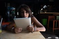 Happy freelance woman using laptop at cafe for work. Young beautiful girl sitting in a coffee shop and working on computer online Royalty Free Stock Photo