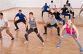 Teenage boys and girls with trainer stretching in dance hall Royalty Free Stock Photo