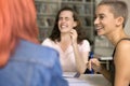 Happy fresh student girl with short haircut meeting with classmates