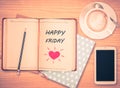 Happy Friday on notebook , pencil, smart phone and coffee cup Royalty Free Stock Photo