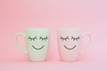 Happy friday word. Two cups of coffee stand together to be heart shape on pink background with smile face on cup. Royalty Free Stock Photo