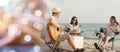 Happy friend have fun playing guitar and clap in camp they smiling together in holiday on sand beach near camping tent Royalty Free Stock Photo