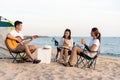 Happy friend have fun playing guitar and clap in camp they smiling together in holiday on sand beach near camping tent Royalty Free Stock Photo