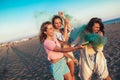 Happy friend walking on beautiful beach in summer sunset in their hands is smoke fontain Royalty Free Stock Photo