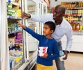 Happy friendly African family of father and tween son shopping together in supermarket Royalty Free Stock Photo